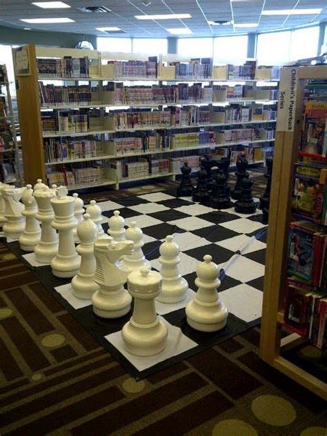 A Large Chess Set In The Middle Of A Library