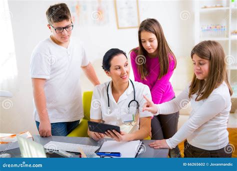Female Doctor And Patient Teenagers Looking At Camera Stock Photo