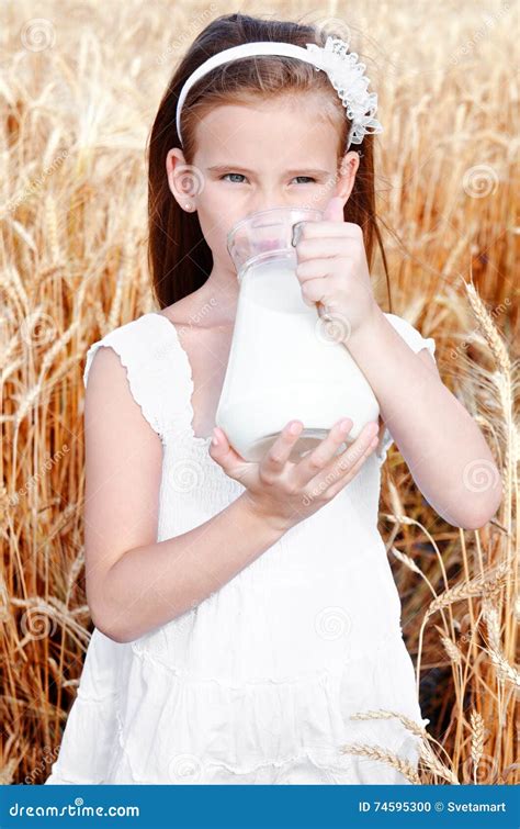 Adorable Little Girl Drinking Milk On Field Of Wheat Stock Photo