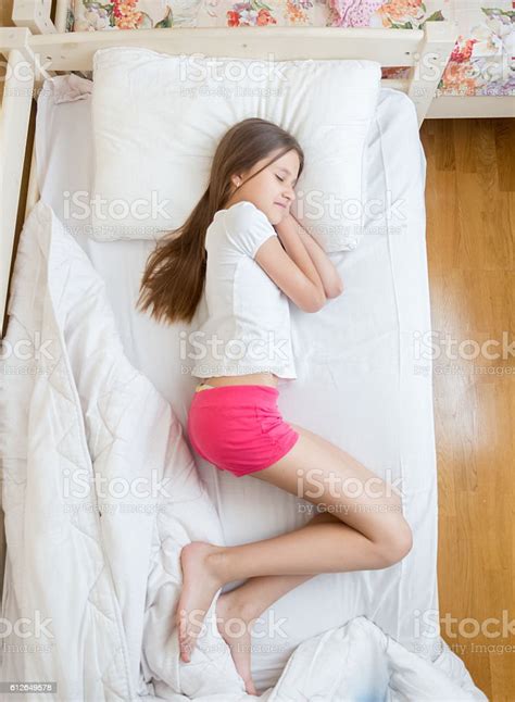 Brunette Teenage Girls In Pink Pajamas Sleeping On Bed Stock Photo