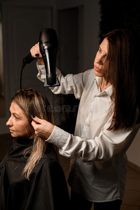 Female Hairdresser Accurate Drying Woman Customer Hair With Hairdryer