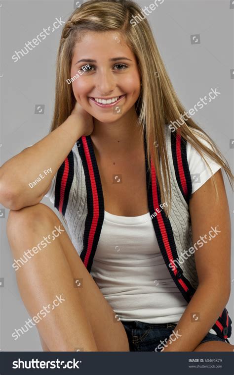 A Pretty Blond Young Teen Girl Sitting And Smiling Stock Photo