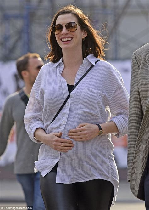 Anne Hathaway Cradles Her Baby Bump While Out With Her Parents In Nyc