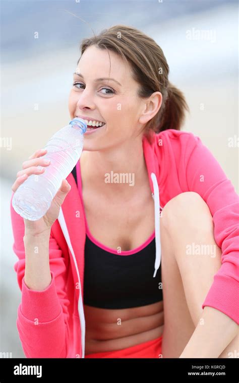 Jogger Drinking Water From Bottle After Exercising Stock Photo Alamy