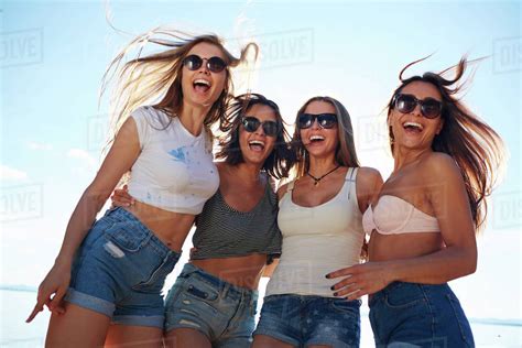 Attractive Girls Laughing At Beach Party By Seaside Stock Photo