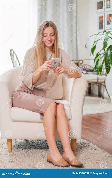 Beautiful Woman Looking At Her Smartphone Is Sitting In Comfortable Chair Stock Image Image Of