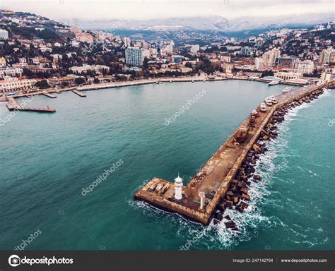 Aerial View Of Yalta Embankment From Drone Old Lighthouse On Pier Sea