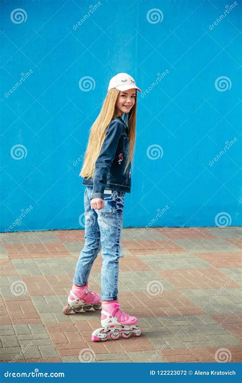 Girl On Rollerblades Sitting On A Bench In A Park And Putting On Inline