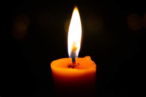 Premium Photo One Light Candle Burning Brightly In The Black Background