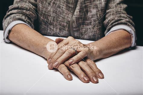 Detail Of Old Womans Hands Resting On Grey Surface Senior Females