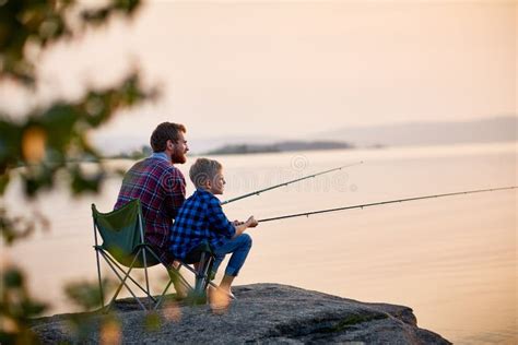 Padre E Hijo Que Disfrutan De La Pesca Junto Imagen De Archivo Imagen