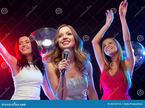 Tres Mujeres Sonrientes Que Bailan Y Que Cantan Karaoke Foto De Archivo Imagen De Bailando