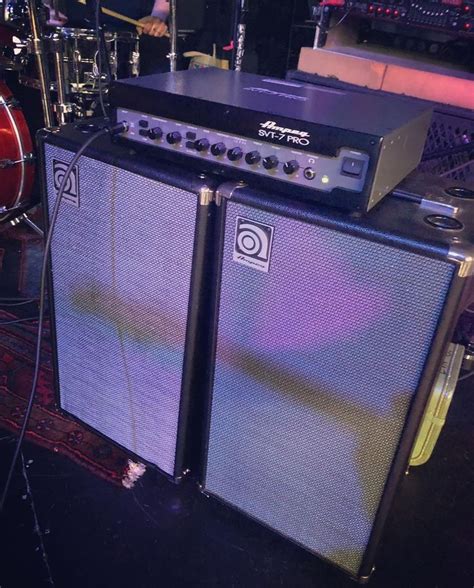 Two Amps Sitting On Top Of Each Other In Front Of Some Guitars And Drums