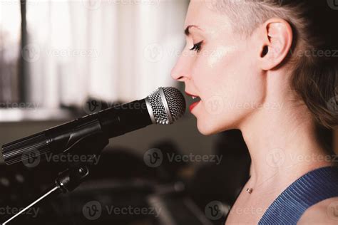 Young Female Rock Singer With Microphone Singing Side View Close Up