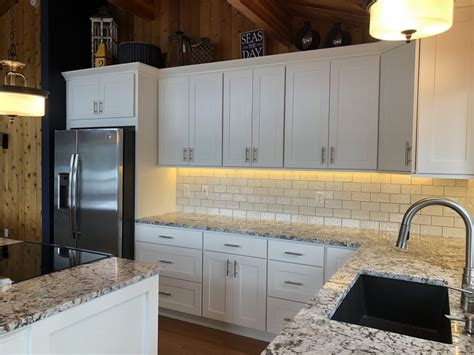Start with the corner cabinet and measure up from the line you drew to the height of the cabinet. 3" fill added to creat light rail. My cabinets are hung 20 ...