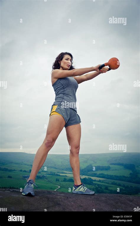 Woman Exercising Outdoors Using A Kettlebell Uk Stock Photo Alamy