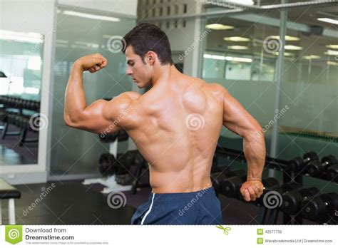 Rear View Of A Muscular Man Flexing Muscles Stock Image Image Of
