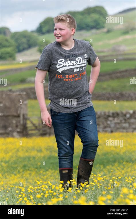 Teenage Farm Boy Walking Through Ildflower Meadow North Yorkshire Uk