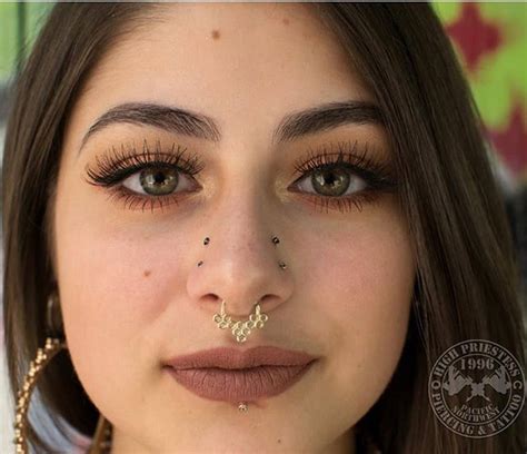 A Woman With Piercings On Her Nose And Nose Ring Looking At The Camera