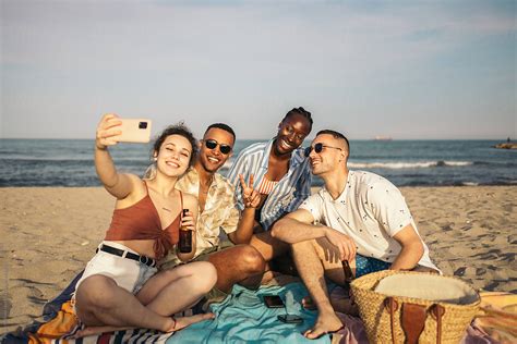 Multiracial Group Of Friends Taking Selfies At The Beach By Stocksy Contributor Pedro Merino