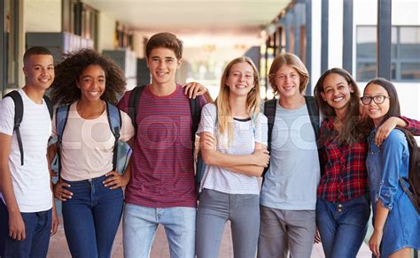 Teenage Classmates Standing In High School Hallway Stock Image
