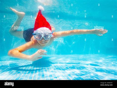 Happy Handsome Boy In Mask Dive And Swim Underwater Wearing Santa Claus
