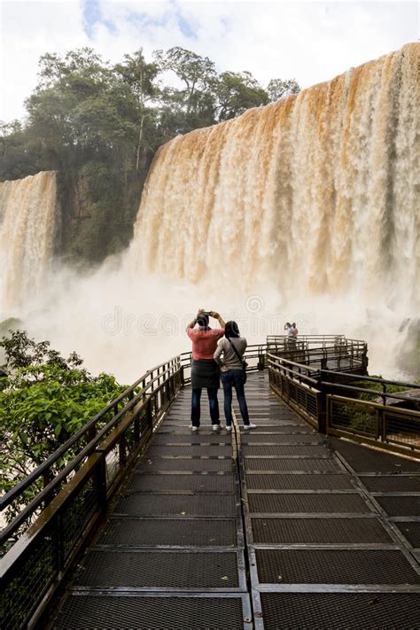 Tourists In The Footbridge At Iguazu Falls Veiw From Argentina