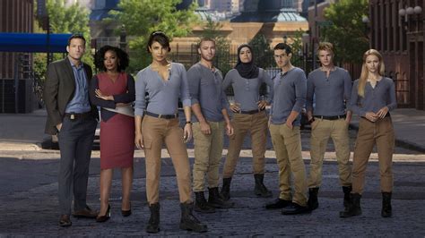 Download Quantico Tv Series Characters Posing In The Foreground Of Fbi Academy Wallpaper
