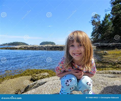 A Happy Girl Smiling For The Camera As She Explores The Coast Of The
