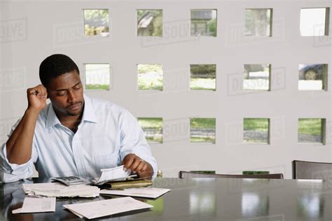 African Man Paying Bills At Table Stock Photo Dissolve