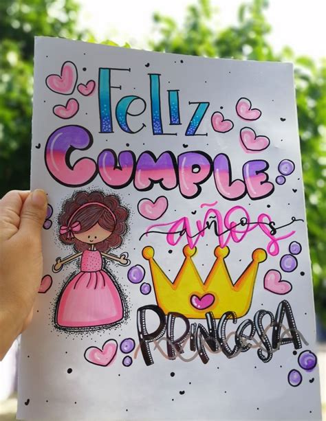 A Person Holding Up A Sign That Says Feliz Cumple And Princessa