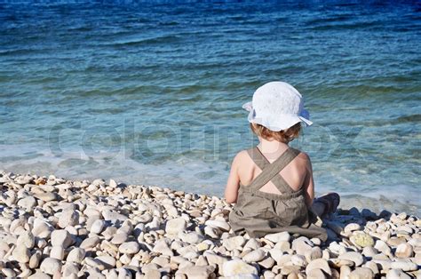Kleines Mädchen Sitzt Am Strand Stock Bild Colourbox