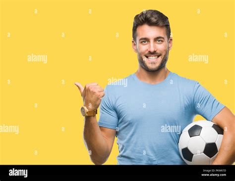 Young Handsome Man Holding Soccer Football Ball Over Isolated