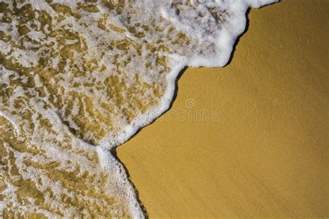 Ocean Water And Foam Washing Up Over Golden Sand In Queensland