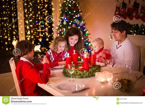 Having to wait through a fabulous dinner for a gaggle of presents is not the worst. Family With Children At Christmas Dinner Stock Photo ...