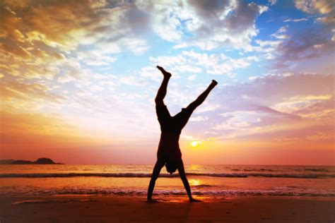 Man Does Handstand On Beach At Sunset Stock Photo Download Image Now