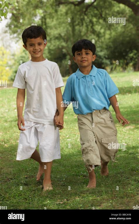 Two Little Boys Holding Hands In A Park Stock Photo Alamy