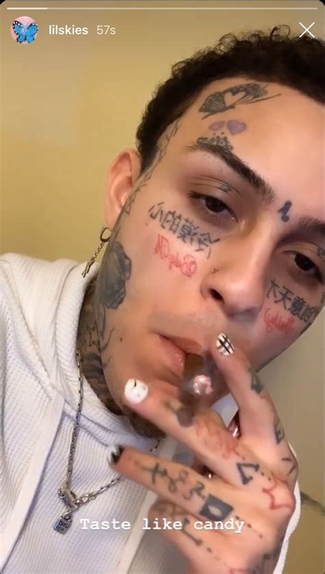 A Man With Lots Of Tattoos On His Face And Hand Holding Something In Front Of Him