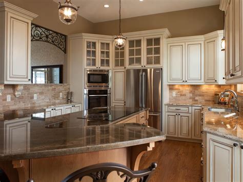The kitchen has an island in the middle made in a similar style. Traditional Ivory Glazed Kitchen With Old World Style | HGTV