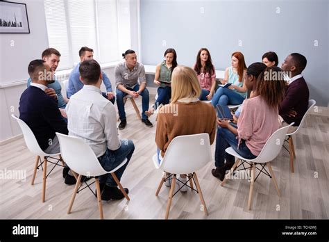 Young Multiracial Millennial Friends Sitting In Circle Having Group