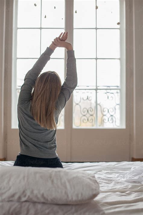 Woman Stretching After Waking Up By Stocksy Contributor Mosuno