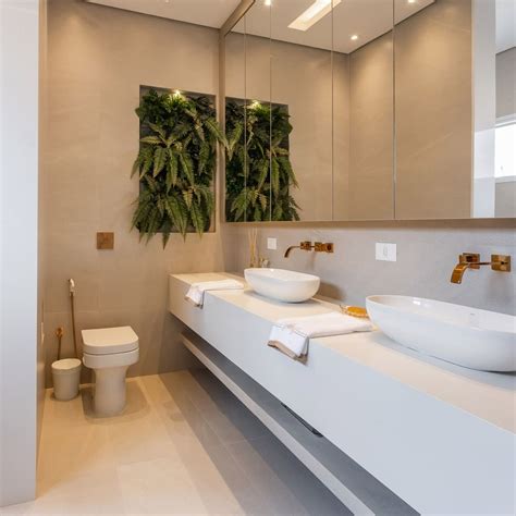 Banheiro neutro com metais dourados jardim vertical e banheira de imersão Decor Salteado