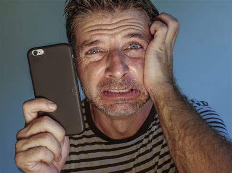 Close Up Face Portrait Of Young Scared And Stressed Man Using Mobile