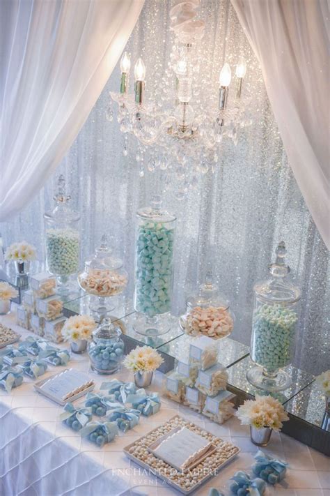 a table topped with lots of candy and candies next to a chandelier