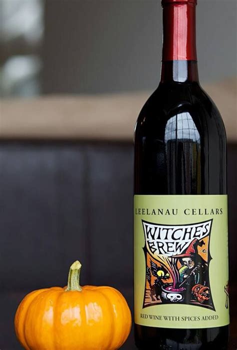 A Bottle Of Wine Sitting Next To A Pumpkin