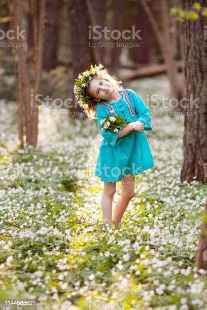 봄 나무에서 걷는 파란 드레스에 아름 다운 어린 소녀 머리에 꽃에서 화 환과 예쁜 여자의 초상화입니다 여름에 야외에서 노는 아이 가족에 대한 스톡 사진 및 기타 이미지