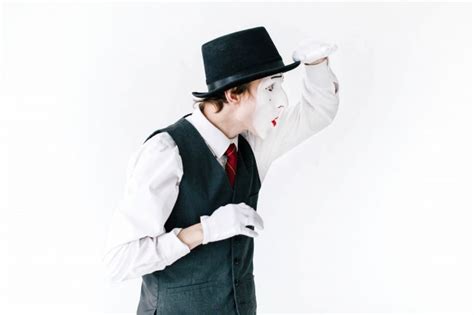 Unser kleines lustiges märchen für kinder beim familienbrunch onkel ben's mittagstisch. Lustige mime in schwarzen hut sieht weit weg auf weißem hintergrund | Download der kostenlosen Fotos