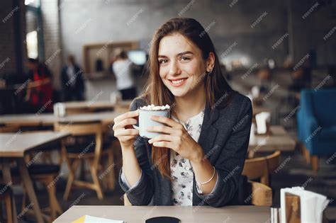 premium photo beautiful and stylish girl sitting in a cafe and drink a coffee