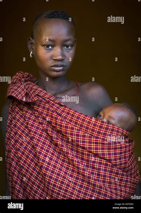 Portrait Of A Bodi Tribe Mother Carrying Her Baby Hana Mursi Omo