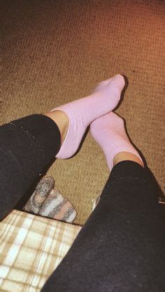 A Person Wearing Pink Socks And Black Pants Sitting On A Couch With